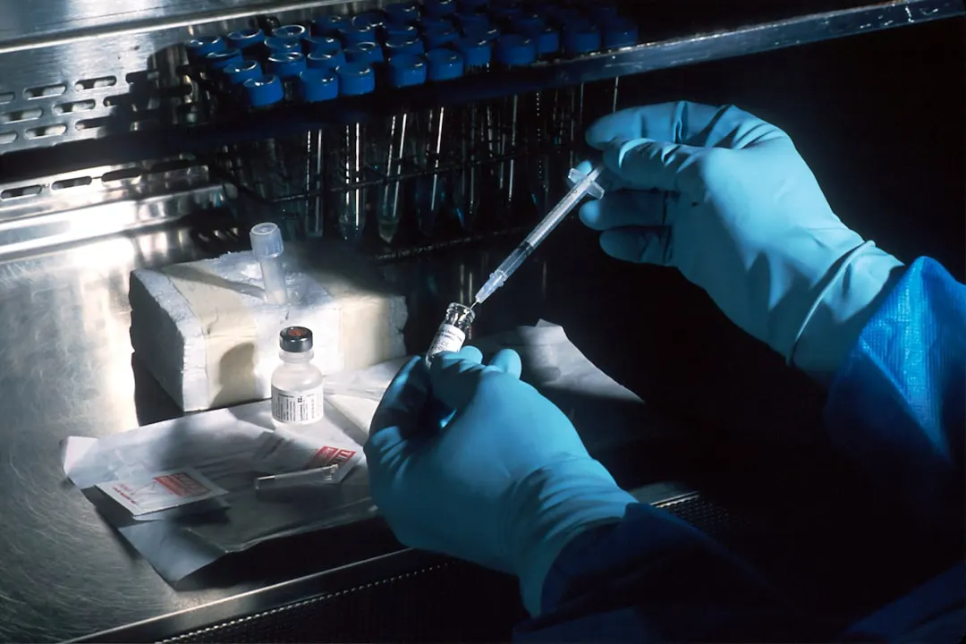 Handen in blauwe handschoenen vullen een spuit in een labo